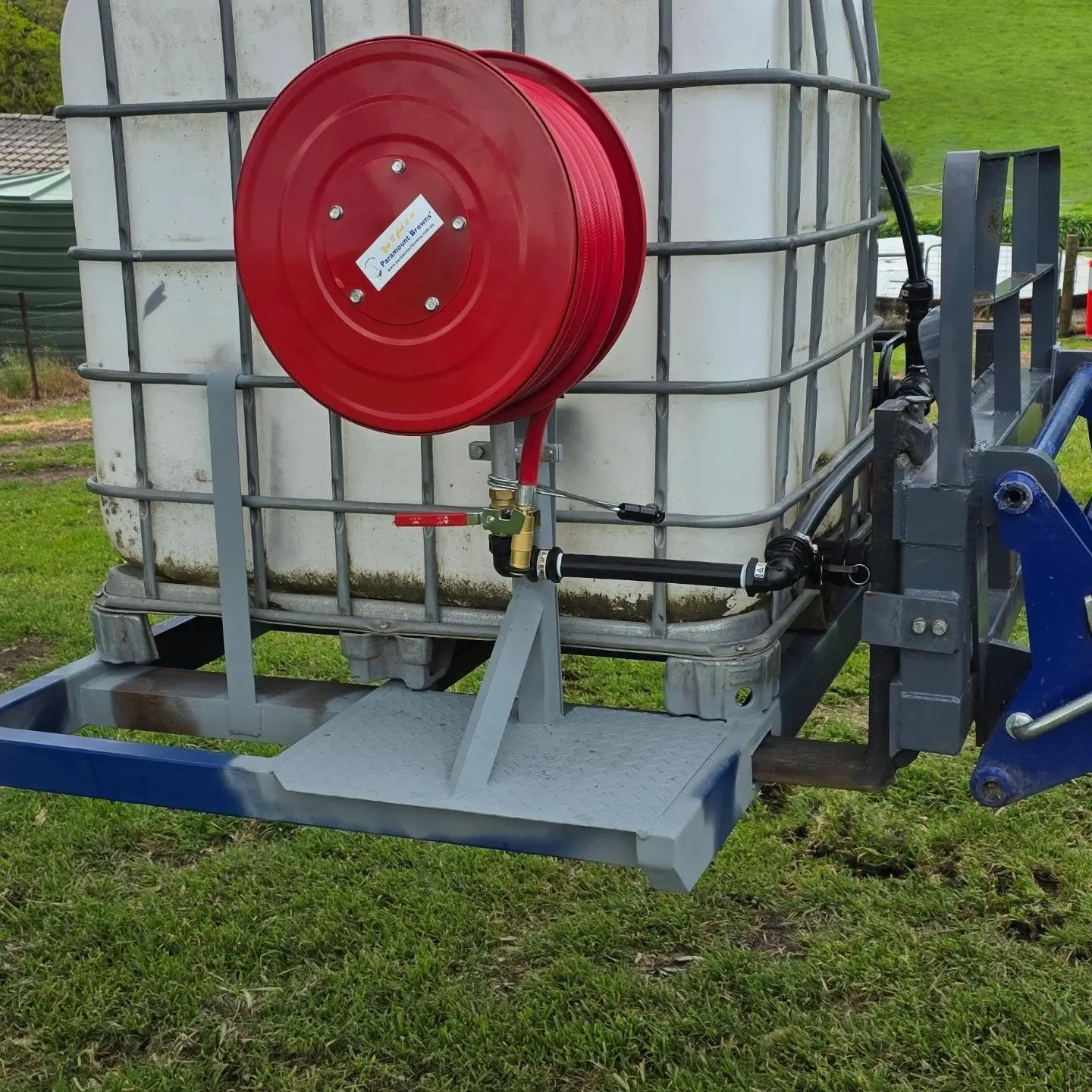 Red hose reel on a welded steel stand on the firefighting skid unit